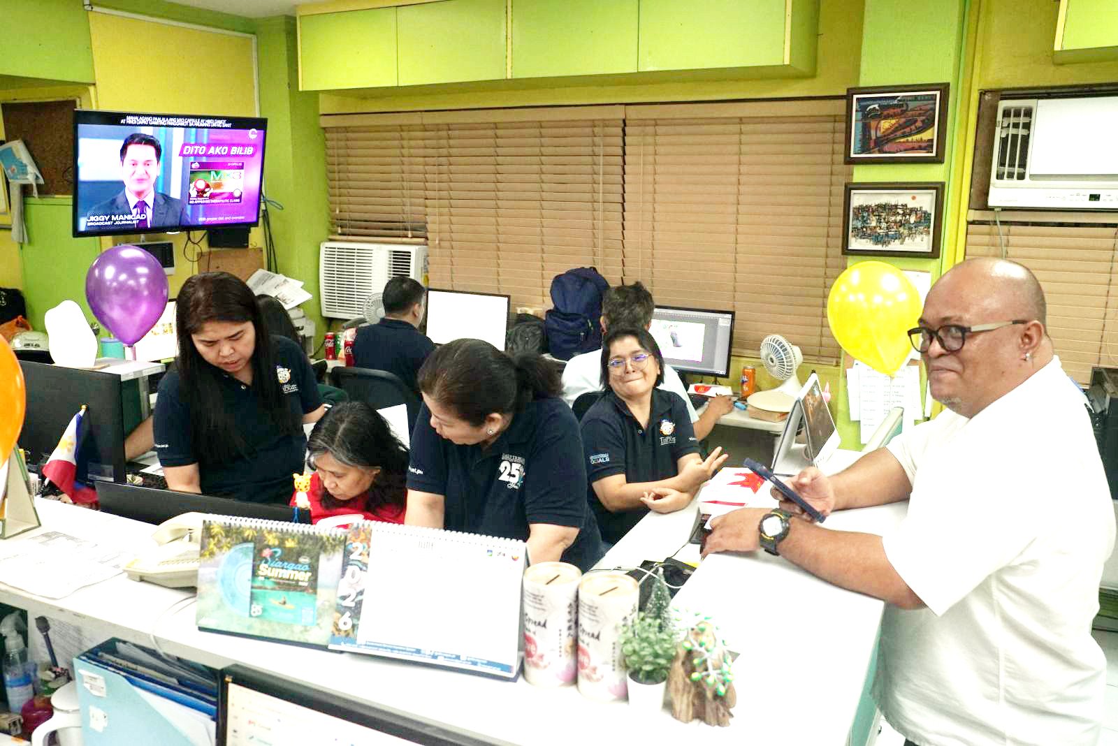 The layout artists’ side share a light moment while putting the DAILY TRIBUNE  pages to bed.