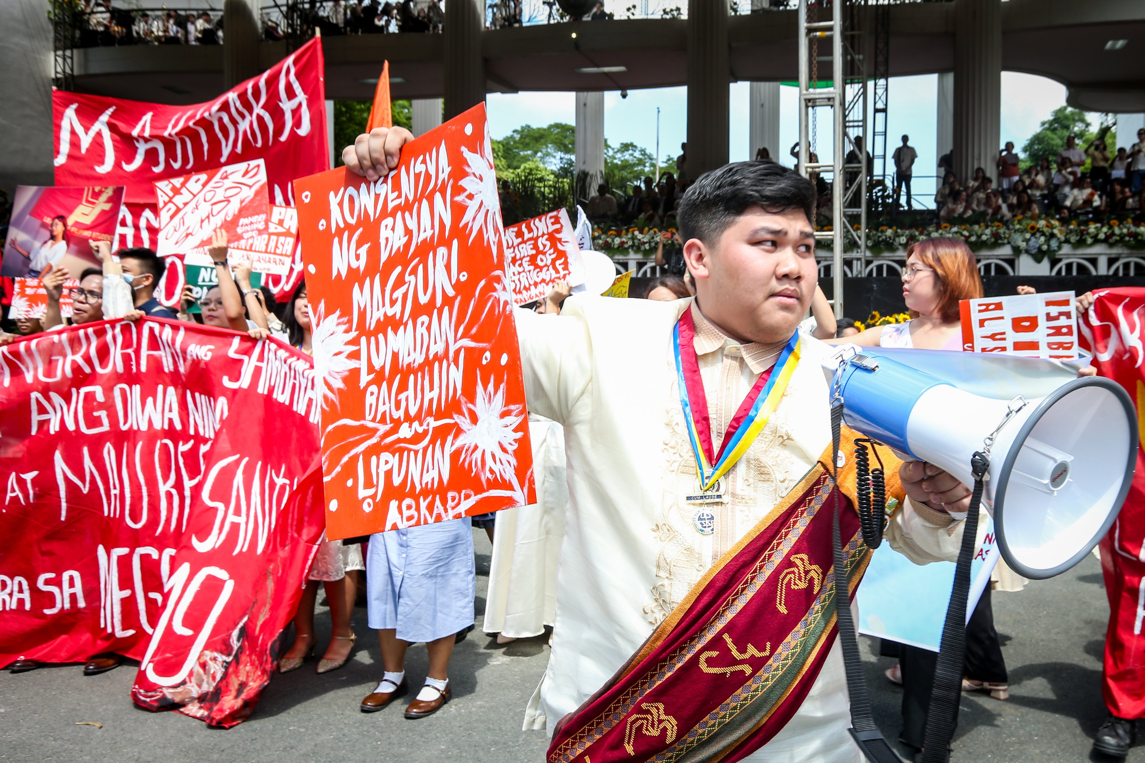 Various progressive graduates staged a protest after the graduation rites ceremony at University of the Philippines Diliman, Quezon City on Sunday, 5 July, 2026. 

Over 5022 students from various degrees celebrated their graduation rites.

Graduates were also seen to strike a pose at the University Avenue of UP Diliman on Sunday, 5 July, 2026 in Quezon City. | Aram Lascano