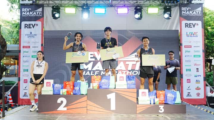SONNY Wagdos (middle) celebrates on top of the medal podium after ruling the 21K race of the REV* Tri-City Half Marathon Makati leg on Sunday at the Ayala Triangle Gardens.