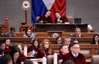 Senate President Win Gatchalian (left) and Presiding Officer Francis Escudero (right) confer during the impeachment trial of Vice President Sara Duterte, as Senate judges and staff take in the proceedings.