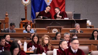 Senate President Win Gatchalian (left) and Presiding Officer Francis Escudero (right) confer during the impeachment trial of Vice President Sara Duterte, as Senate judges and staff take in the proceedings.