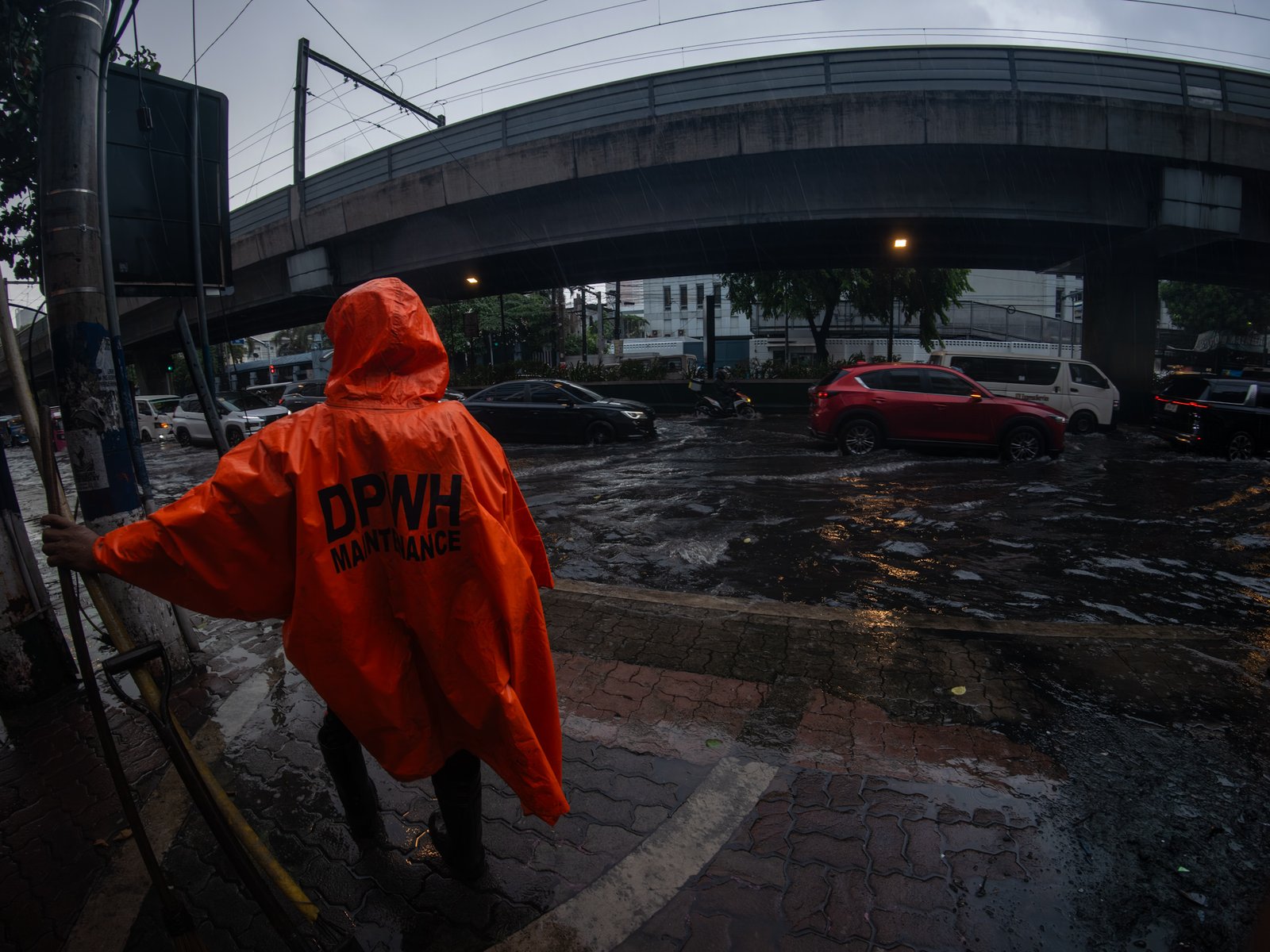 Department of Public Works and Highways personnel declog a portion of Taft Avenue in Manila on Friday after a sudden downpour brought by the southwest monsoon, enhanced by Typhoon Inday, caused flooding.