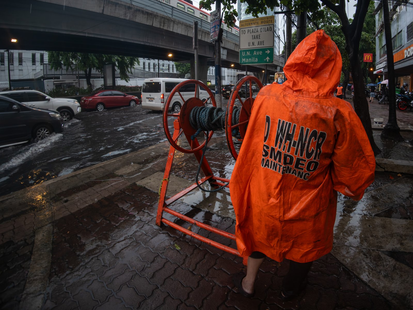 Department of Public Works and Highways personnel declog a portion of Taft Avenue in Manila on Friday after a sudden downpour brought by the southwest monsoon, enhanced by Typhoon Inday, caused flooding.