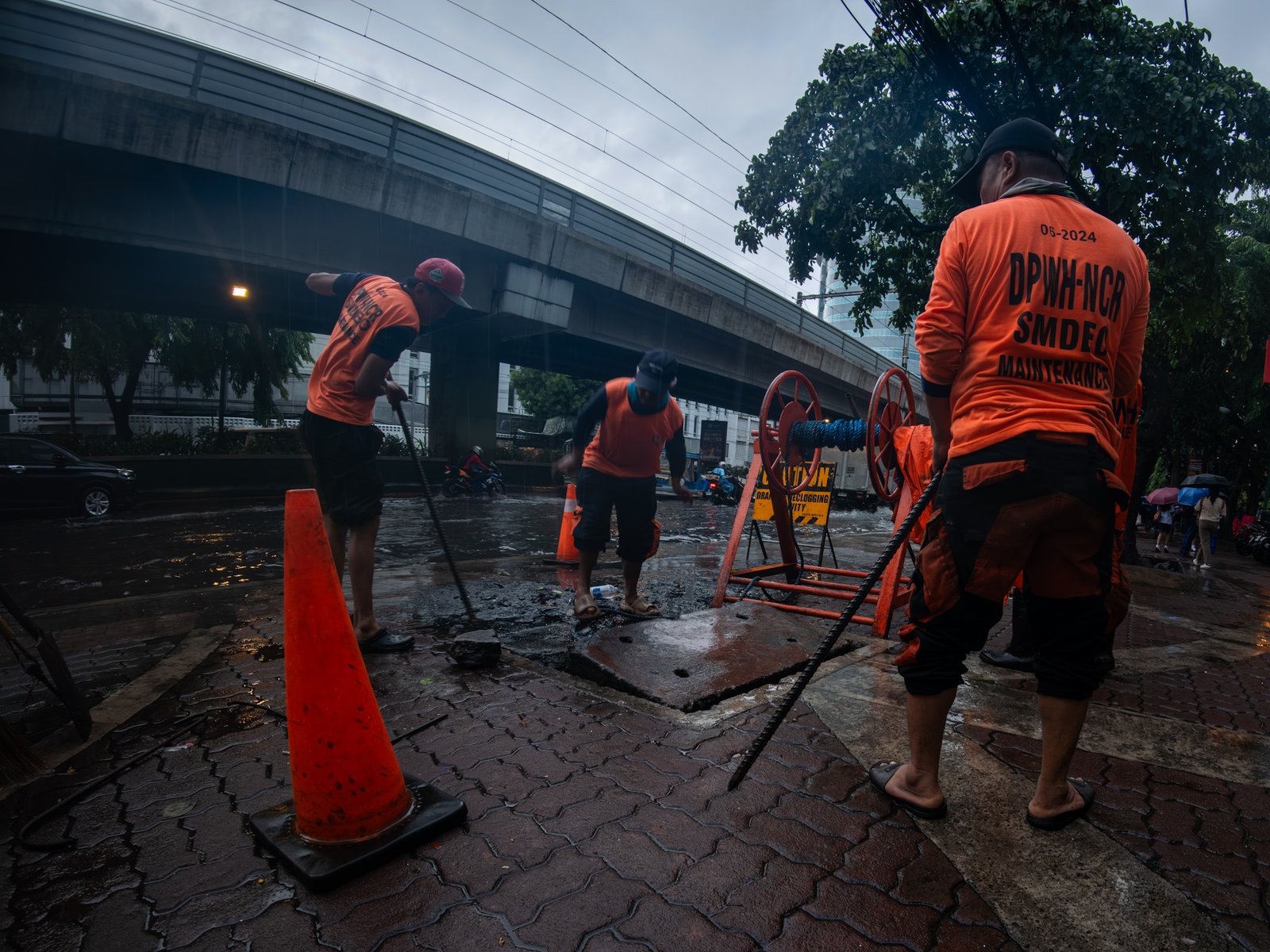 Department of Public Works and Highways personnel declog a portion of Taft Avenue in Manila on Friday after a sudden downpour brought by the southwest monsoon, enhanced by Typhoon Inday, caused flooding.