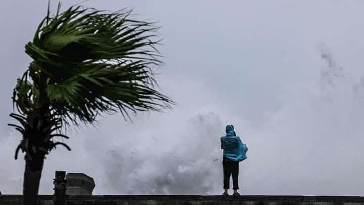 A PERSON looks on as large waves crash against the coast in Keelung, off northeastern Taiwan, on 11 July 2026.