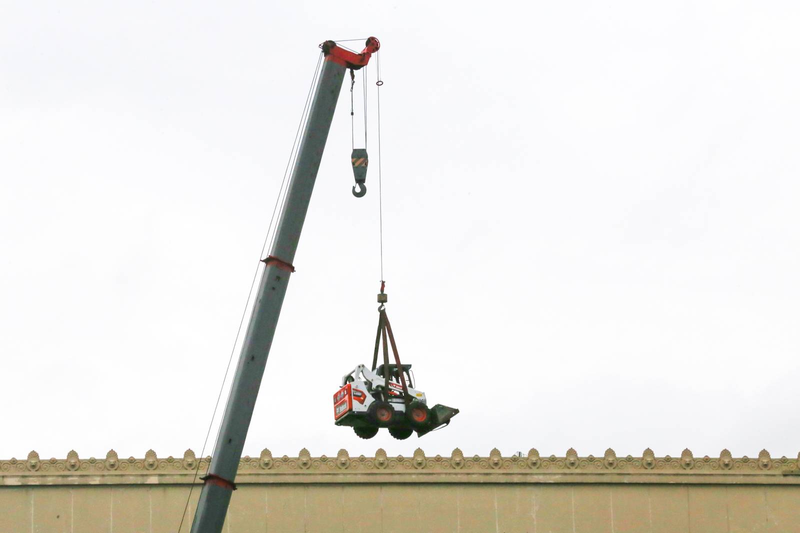 A crane lifts a mini pail loader onto the roof of the Manila Central Post Office at Liwasang Bonifacio in Manila. The century-old Neoclassical landmark, designed by architects Juan M. Arellano, Tomás Mapúa, and Ralph Doane, is undergoing extensive repairs and renovation after a major fire severely damaged the building two years ago.