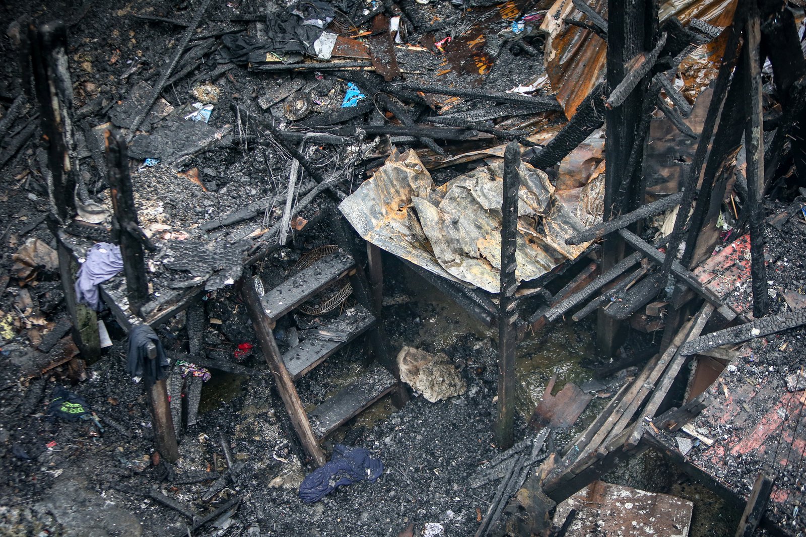A fourth-alarm fire razed 46 houses beneath Culiat Bridge II along Congressional Avenue in Quezon City on Saturday night before it was declared out at 11:26 p.m. The Quezon City government said 38 families were affected, including residents of a nearby house. Authorities continue to assess the damage, with road closures in place as investigators examine the area, where damaged utility lines and a long crack on the bridge's asphalt surface were observed.