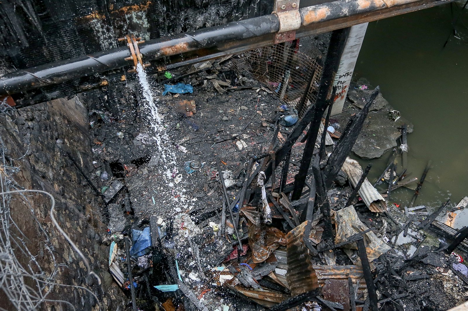 A fourth-alarm fire razed 46 houses beneath Culiat Bridge II along Congressional Avenue in Quezon City on Saturday night before it was declared out at 11:26 p.m. The Quezon City government said 38 families were affected, including residents of a nearby house. Authorities continue to assess the damage, with road closures in place as investigators examine the area, where damaged utility lines and a long crack on the bridge's asphalt surface were observed.