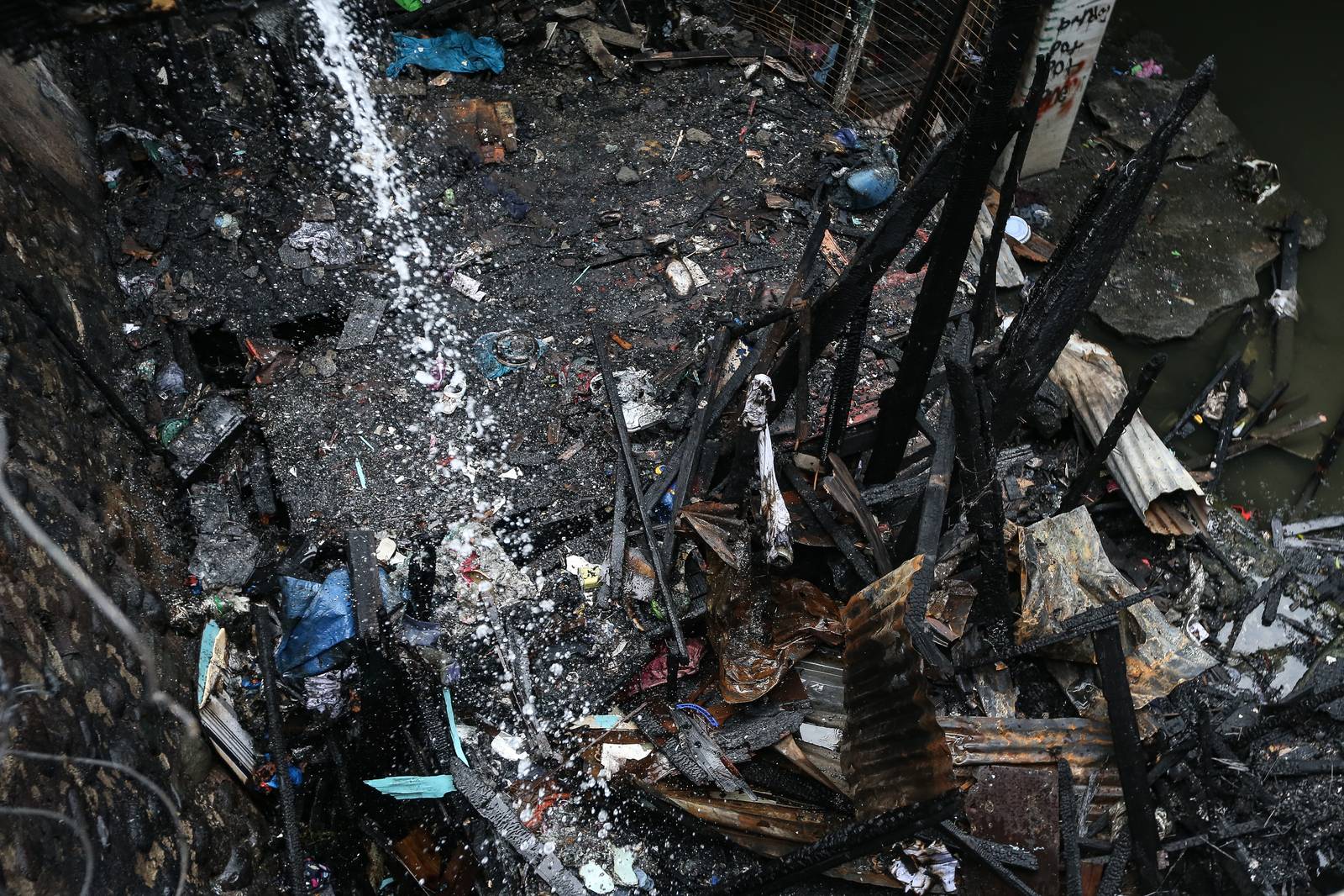 A fourth-alarm fire razed 46 houses beneath Culiat Bridge II along Congressional Avenue in Quezon City on Saturday night before it was declared out at 11:26 p.m. The Quezon City government said 38 families were affected, including residents of a nearby house. Authorities continue to assess the damage, with road closures in place as investigators examine the area, where damaged utility lines and a long crack on the bridge's asphalt surface were observed.