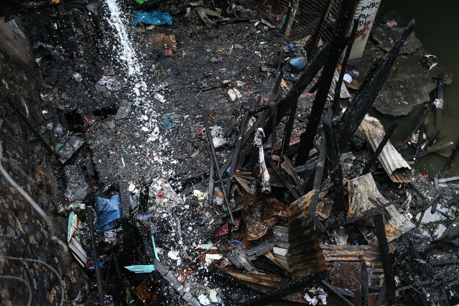 A fourth-alarm fire razed 46 houses beneath Culiat Bridge II along Congressional Avenue in Quezon City on Saturday night before it was declared out at 11:26 p.m. The Quezon City government said 38 families were affected, including residents of a nearby house. Authorities continue to assess the damage, with road closures in place as investigators examine the area, where damaged utility lines and a long crack on the bridge's asphalt surface were observed.