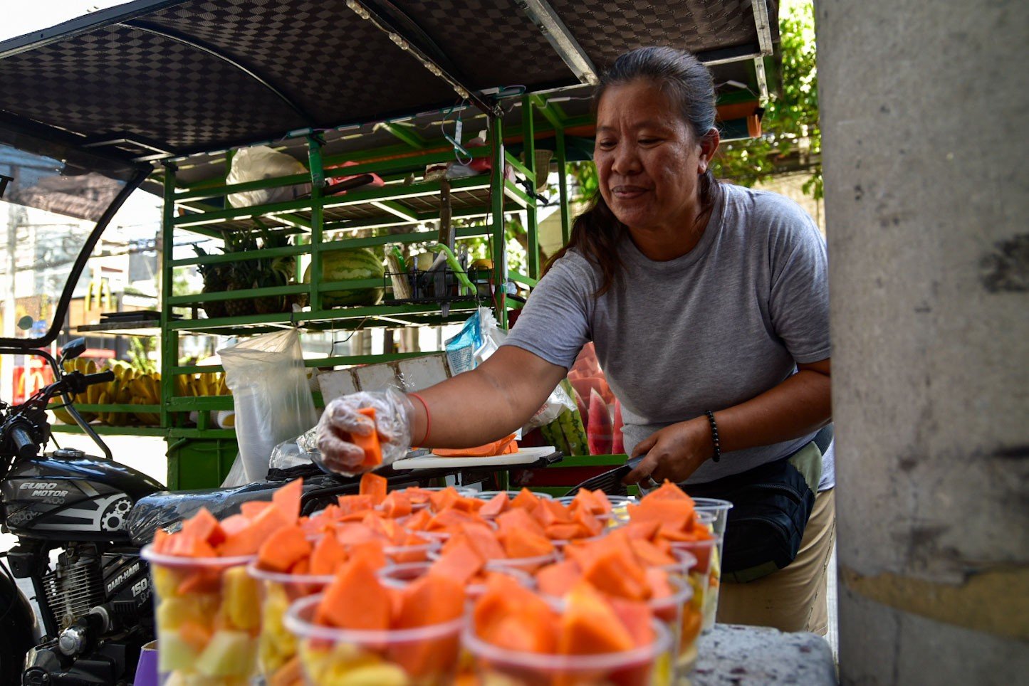 Woman selling sliced fruits in Manila