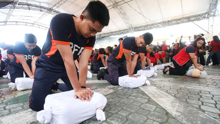 Philippine Red Cross volunteers and participants perform a hands-on cardiopulmonary resuscitation demonstration during National CPR Day at Risen Garden in Quezon City Hall on Friday.