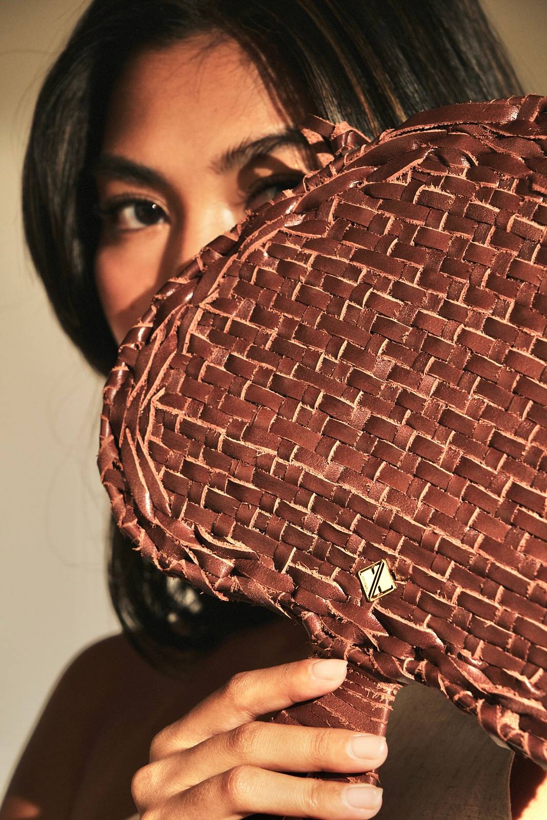 Aranaz ‘Pamaypay’ clutch, a brown handwoven leather ‘pamaypay’ featuring a small gold-toned logo plaque.