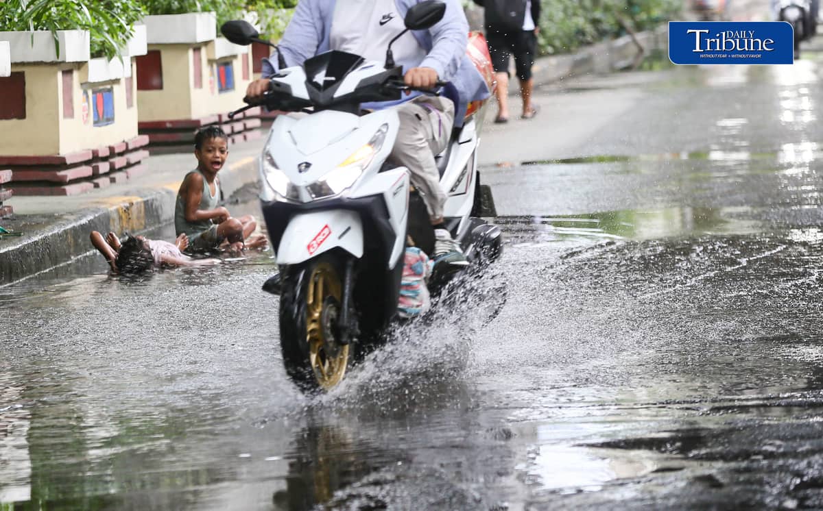 (July 25 2026) Two children turned the water collected from the heavy rain along Edsa on Saturday afternoon into a swimming pool. Photo/Analy Labor