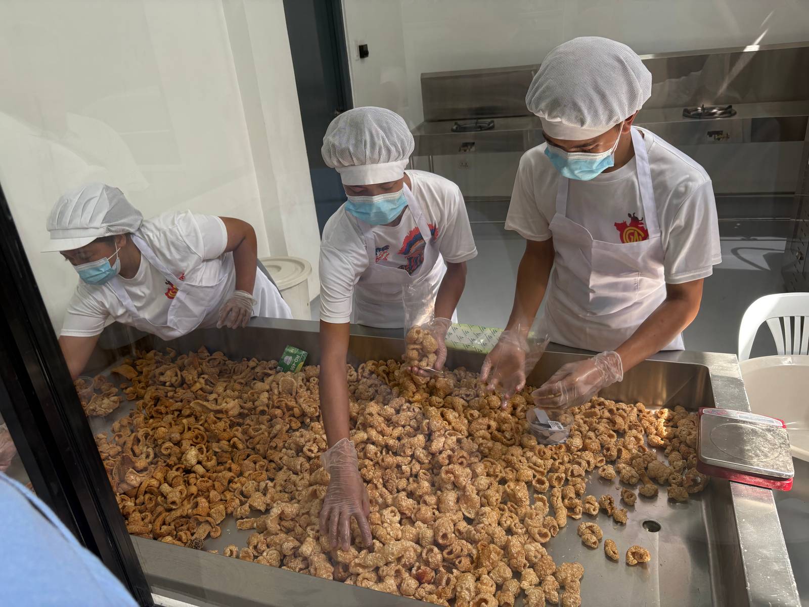 Workers process pork rind snacks inside a Department of Science and Technology-assisted food processing plant.