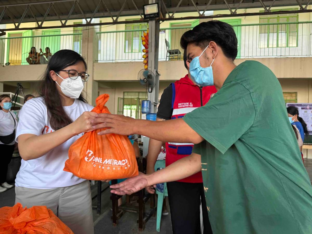 Disaster response. OMF employee volunteers distributing relief packs to the affected residents of the fire incidenr in the Navotas landfill.