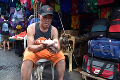 A man feeding a kitten in Divisoria, Manila