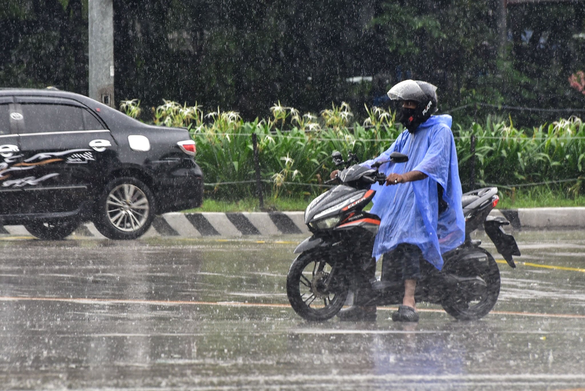 Pedestrians seen with raincoats and umbrellas due to heavy rainfall Manila