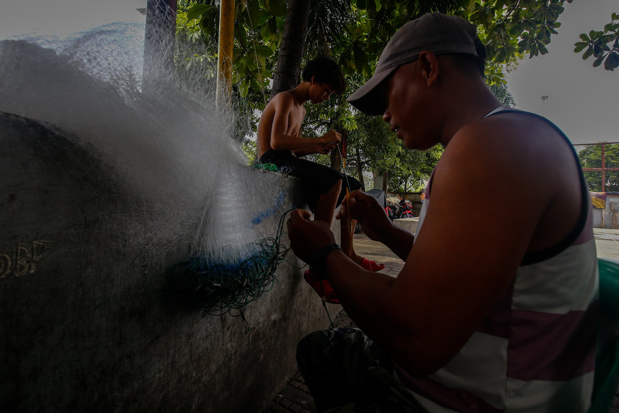 Fishermen repair nets at Pescador Park