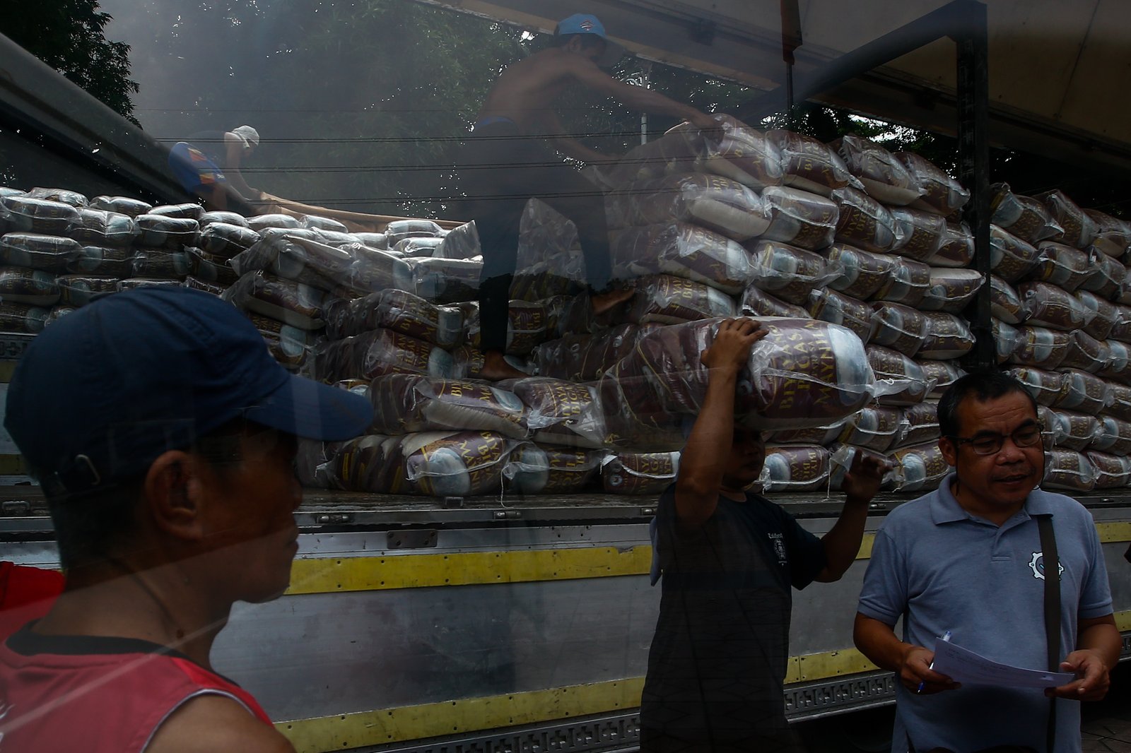 Workers unload sacks of rice for the third tranche of the "Biyayang Bigas para sa Maynila" program at the Kartilya ng Katipunan on July 30, 2026. The Marcos administration's initiative provides subsidized rice to workers in the City of Manila and, according to the administration, aims to help families cope with ongoing economic pressures while supporting local rice farmers.
