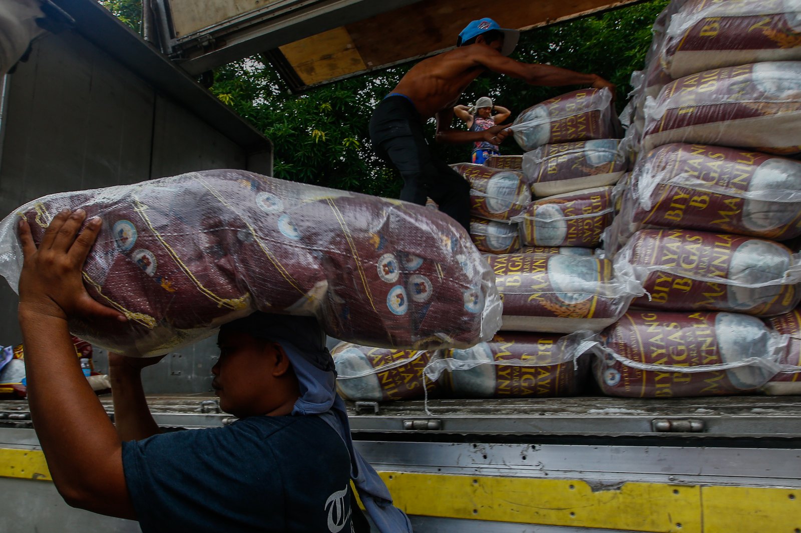 Workers unload sacks of rice for the third tranche of the "Biyayang Bigas para sa Maynila" program at the Kartilya ng Katipunan on July 30, 2026. The Marcos administration's initiative provides subsidized rice to workers in the City of Manila and, according to the administration, aims to help families cope with ongoing economic pressures while supporting local rice farmers.