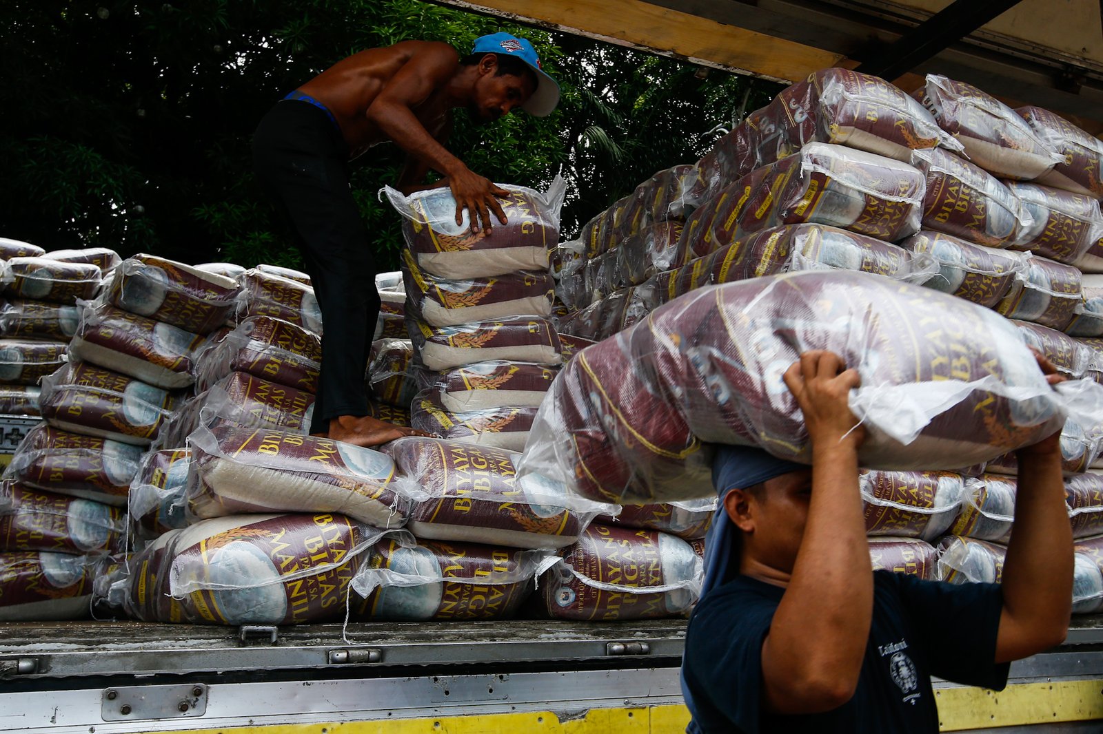 Workers unload sacks of rice for the third tranche of the "Biyayang Bigas para sa Maynila" program at the Kartilya ng Katipunan on July 30, 2026. The Marcos administration's initiative provides subsidized rice to workers in the City of Manila and, according to the administration, aims to help families cope with ongoing economic pressures while supporting local rice farmers.