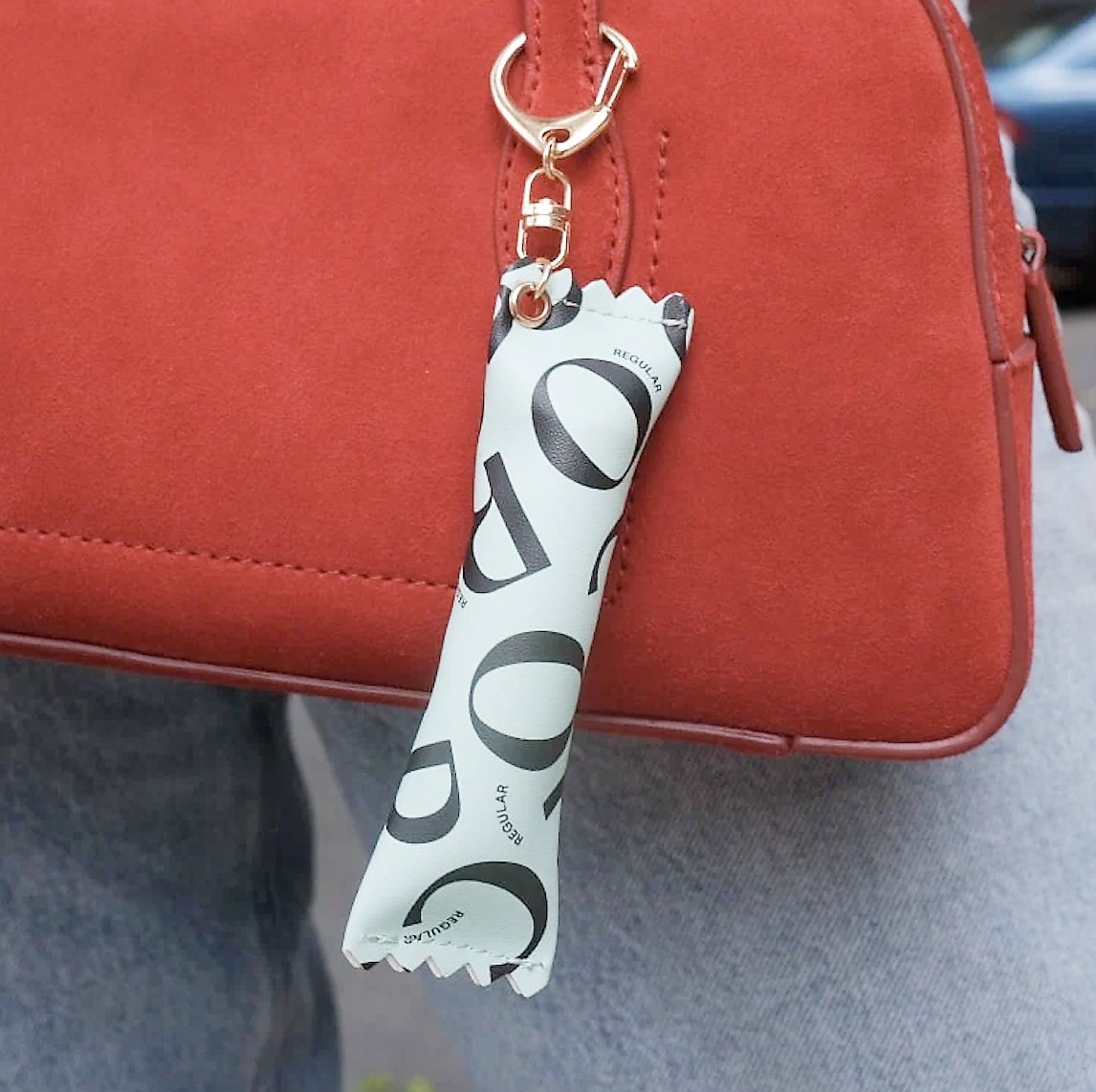 CORA bag charm that can hold a single tampon.