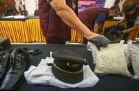 INDONESIAN customs officials prepare to display the uniform of a Malaysian pilot and drugs he smuggled as evidence before a press conference at Soekarno-Hatta International Airport in Tangerang, near Jakarta, on 31 July 2026.