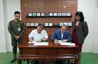 BRIG. Gen. Marces T. Gayat (left), commander of the Civil Military Operations Regiment, and Capt. Paul J. Gayanilo (right), vice president for Facility Security of Solaire Entertainment City, sign the deed of donation during the turnover ceremony at the CMOR's Kaamulan Hall in Fort Bonifacio, Taguig City.