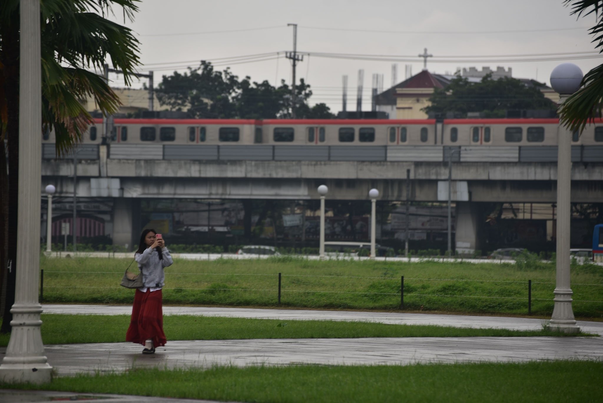 Visitors stroll around Rizal Park despite rain