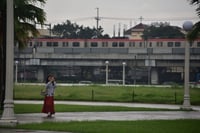 Visitors stroll around Rizal Park despite rain