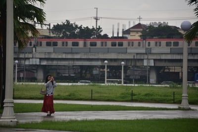 Visitors stroll around Rizal Park despite rain