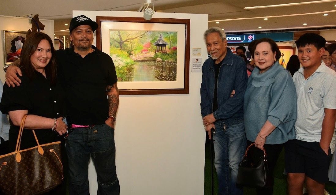 Elena Fernandez beside her Peaceful Garden artwork with her family led by her husband Dr. Manuel Fernandez Jr.