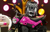 CELEBRATING the Honda x Dunkin partnership, a rider poses beside the Neon Pink Honda NAVi.