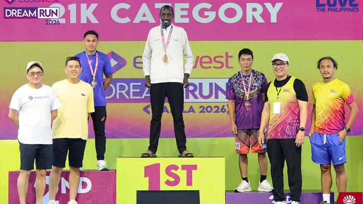 Evans Bomer celebrates on top of the medal podium after ruling the EastWest Dream Run 2026 on Sunday at The Filinvest Tent in Alabang.