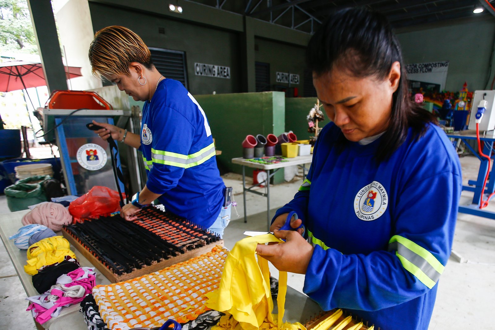 Mary Ann Doble, Loida Domingo and Marilou Reposo transform worn-out T-shirts into rags and mats at a materials recovery facility in Manila on 4 August 2026. The three women learned the upcycling craft through online tutorials.