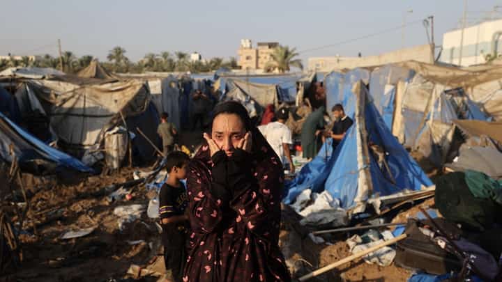 A displaced Palestinian woman reacts as she surveys the destruction of tent shelters following an Israeli airstrike near a medical supplies warehouse belonging to Al-Aqsa Martyrs Hospital in Deir el-Balah, central Gaza Strip, on 1 August.