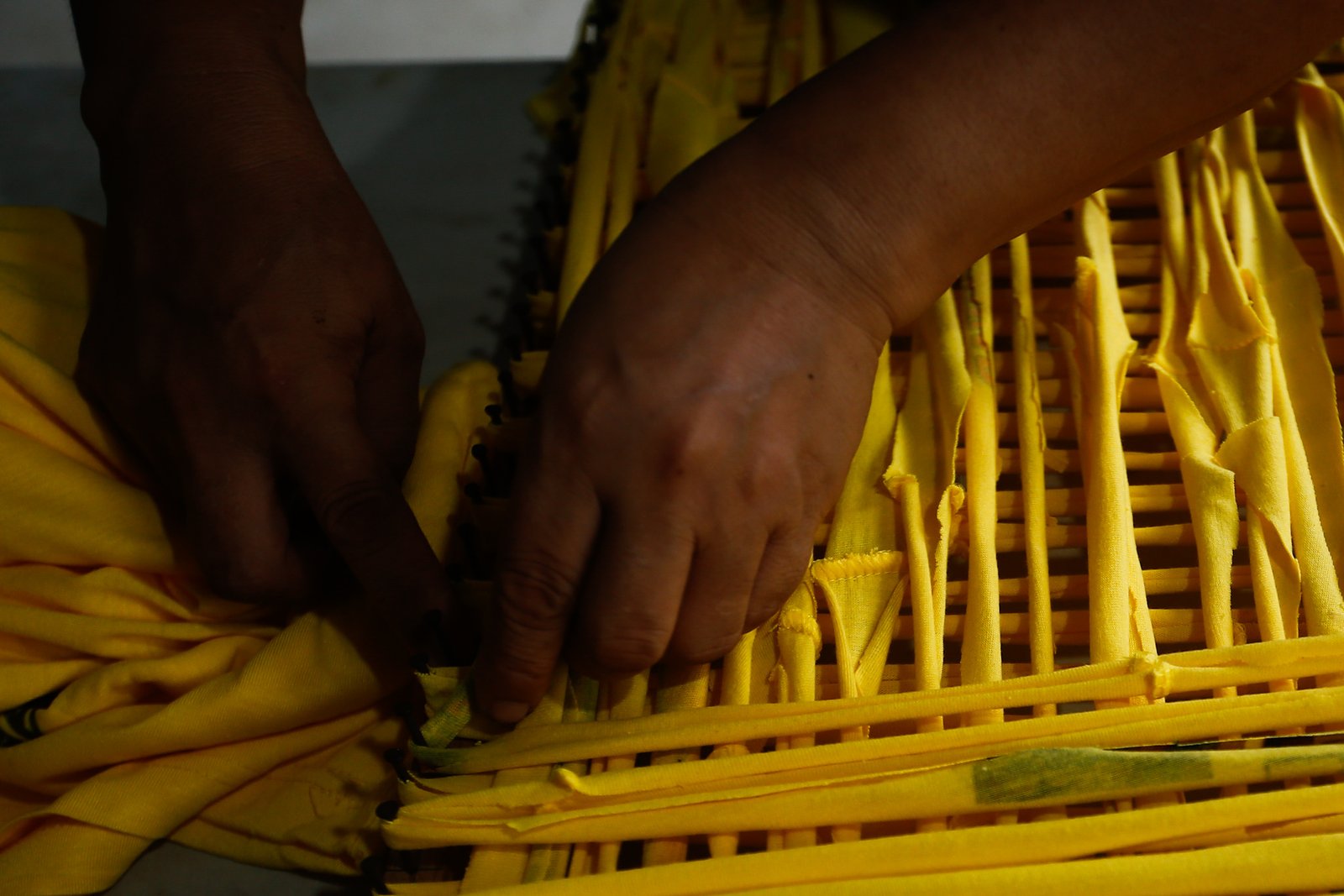 Mary Ann Doble, Loida Domingo and Marilou Reposo transform worn-out T-shirts into rags and mats at a materials recovery facility in Manila on 4 August 2026. The three women learned the upcycling craft through online tutorials.