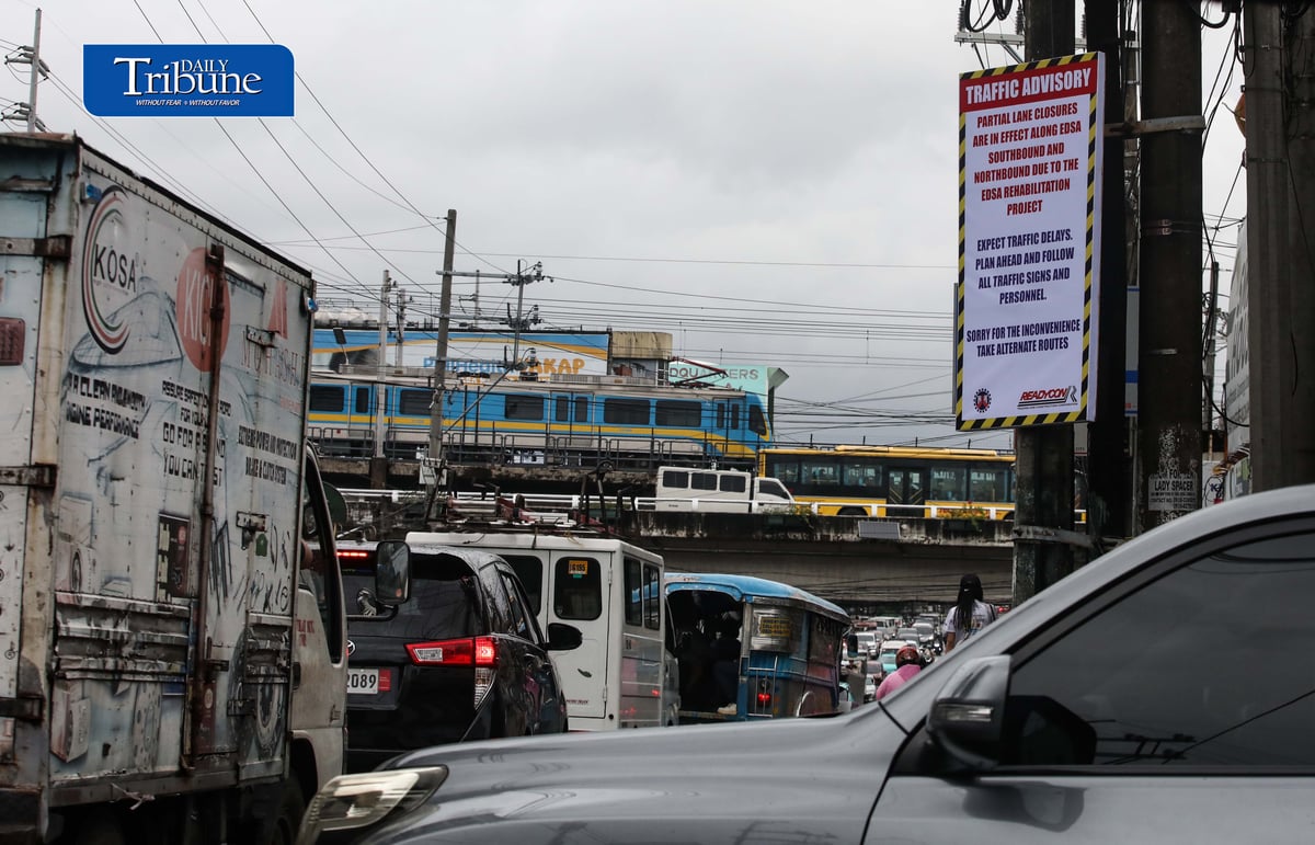 (August 06 2026) An advisory tarpaulins from the Department of Public Works and Highways (DPWH) to expect heavy traffic due to the EDSA Rehabilitation Project seen hang along Kamuning Road corner Edsa in Quezon City on Thursday august 6 2026, as motorists passes by and the MTR3 Dalian train, The DPWH plans to conduct partial lane closures along the southbound lane of EDSA from Monumento to Guadalupe, and advises the public to take alternative routes. Photo/Analy Labor