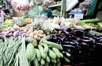 A vegetable vendor waits for customers at her stall inside the Kamuning Market in Quezon City.