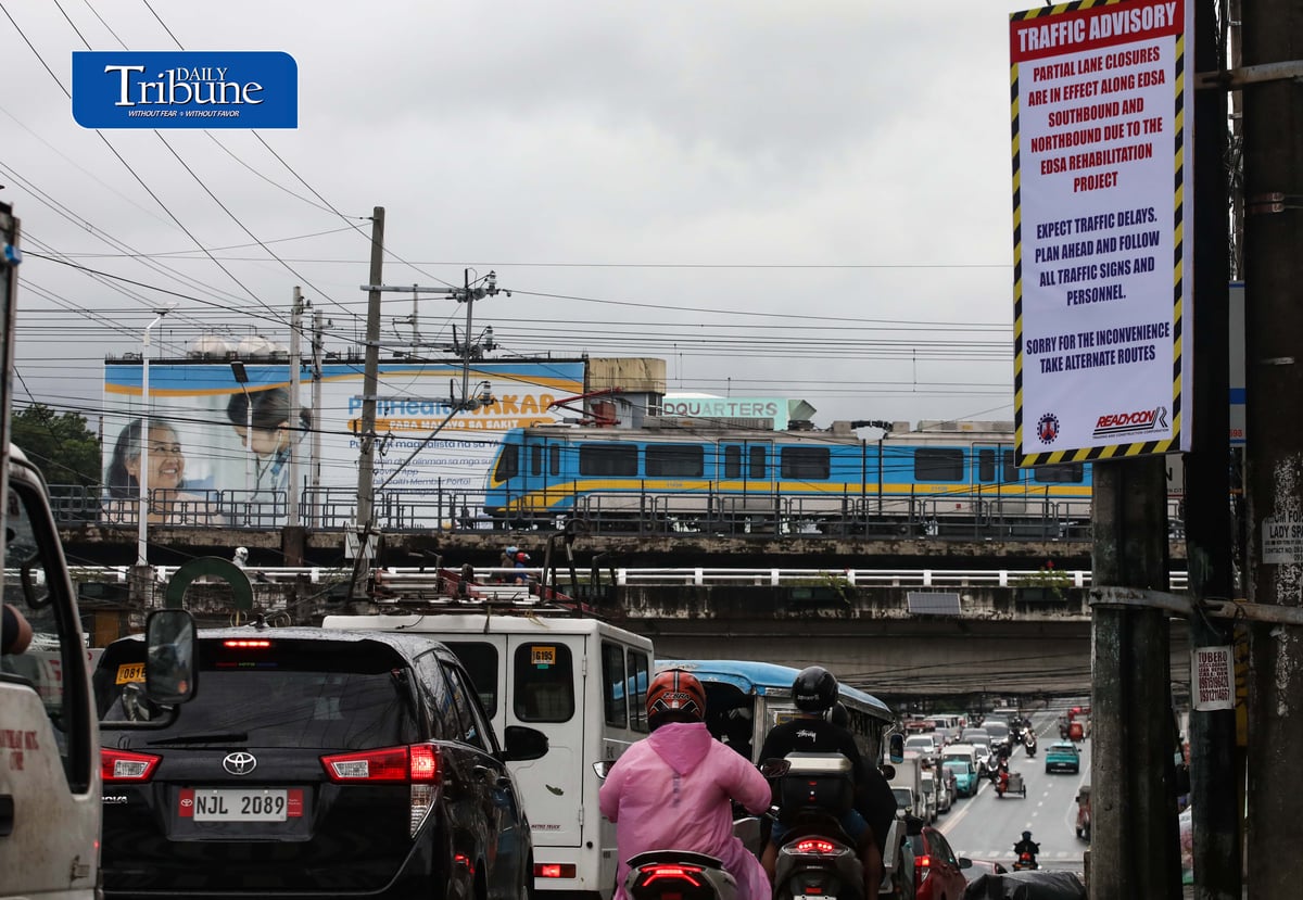(August 06 2026) An advisory tarpaulins from the Department of Public Works and Highways (DPWH) to expect heavy traffic due to the EDSA Rehabilitation Project seen hang along Kamuning Road corner Edsa in Quezon City on Thursday august 6 2026, as motorists passes by and the MTR3 Dalian train, The DPWH plans to conduct partial lane closures along the southbound lane of EDSA from Monumento to Guadalupe, and advises the public to take alternative routes. Photo/Analy Labor