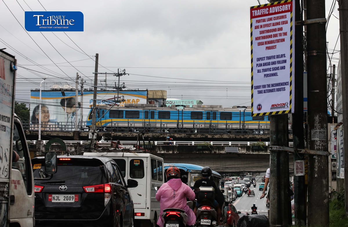(August 06 2026) An advisory tarpaulins from the Department of Public Works and Highways (DPWH) to expect heavy traffic due to the EDSA Rehabilitation Project seen hang along Kamuning Road corner Edsa in Quezon City on Thursday august 6 2026, as motorists passes by and the MTR3 Dalian train, The DPWH plans to conduct partial lane closures along the southbound lane of EDSA from Monumento to Guadalupe, and advises the public to take alternative routes. Photo/Analy Labor