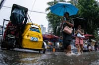 Motorists and commuters wade through gutter-deep floodwaters at the corner of Taft Avenue and Escoda Street in Manila on August 8, 2026, after PAGASA issued an Orange Rainfall Warning over Metro Manila at 11:02 a.m.