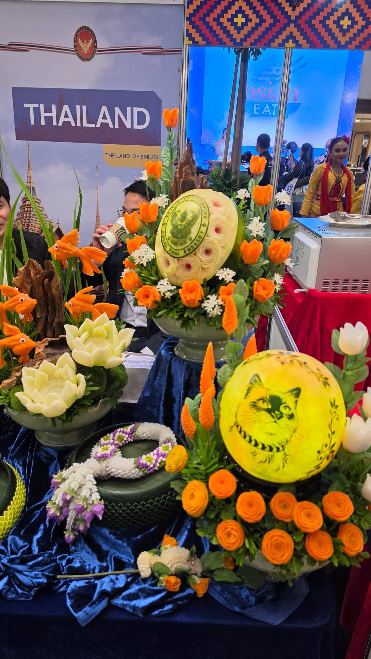 Intricate fruit carvings and floral arrangements enliven the Thai booth at Asian Eats 2026.