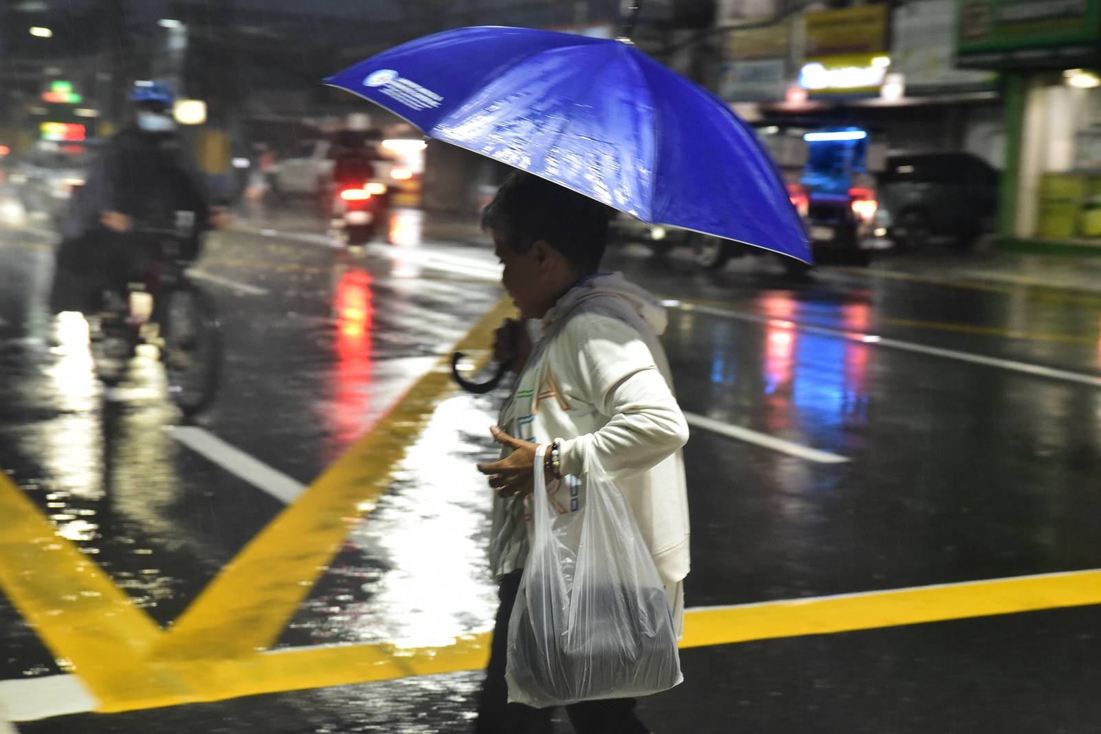 Motorists along Emilio Aguinaldo Highway use umbrellas as they brave heavy rainfall brought by the enhanced southwest monsoon, or habagat, on August 8. | Zedrich Xylak Madrid