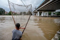 Fishing along the swollen Tumana