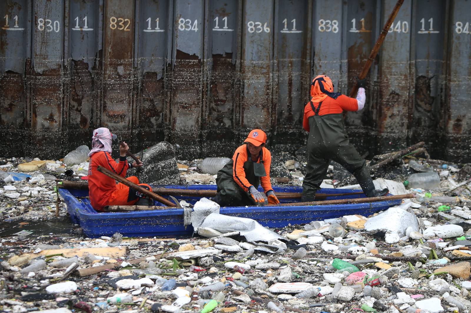 Personnel work through the rain to clear a massive buildup of garbage from the Redemptorist Water Channel in Parañaque City on Tuesday afternoon, 11 August. | Aram Lascano