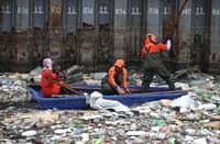 Personnel work through the rain to clear a massive buildup of garbage from the Redemptorist Water Channel in Parañaque City on Tuesday afternoon, 11 August. | Aram Lascano