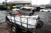 MOTORIST carry milkfish through deep floodwaters along MacArthur Highway in Barangay Santa Monica, San Simon, Pampanga.