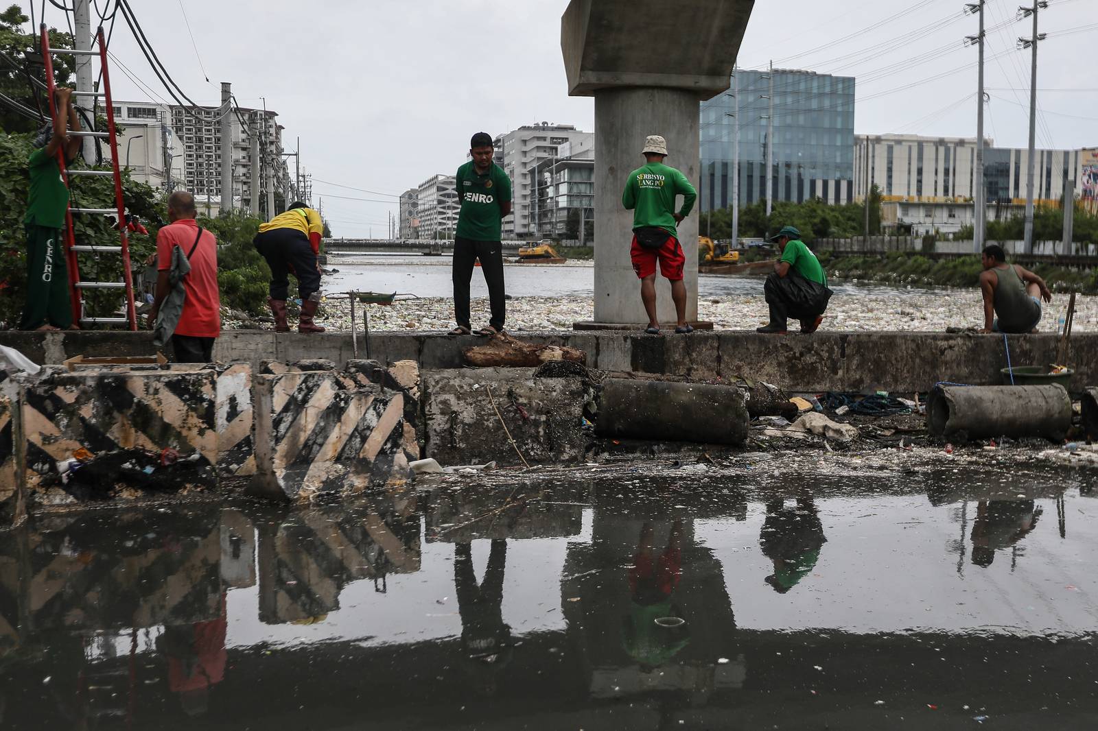 Personnel work through the rain to clear a massive buildup of garbage from the Redemptorist Water Channel in Parañaque City on Tuesday afternoon, 11 August. | Aram Lascano